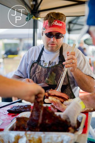 Andy Brent with the Meat Militia team cuts a rack of spare ribs during the Atlanta Bar-B-Q Festival at Atlantic Station in Midtown on Saturday, September 14, 2013. 