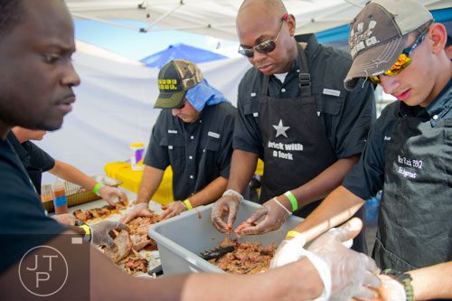 August Prince (right), Ed Barnes, Stefan Woulfin and Jeremy Jenkins prepare pulled pork for the Nice Rack BBQ team during the fifth annual Atlanta Bar-B-Q Festival at Atlantic Station in Midtown on Saturday, September 14, 2013.