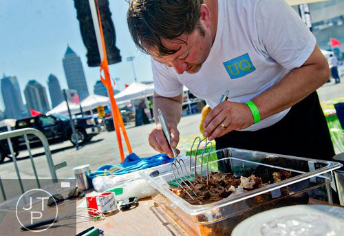 Zachary Link uses forks to put the finishing touches on his pulled pork during the Atlanta Bar-B-Q Festival at Atlantic Station in Midtown on Saturday, September 14, 2013. 