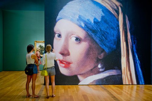 Jenny Bradley (left) and Kate Bradley study a blown up image of Johannes Vermeer’s iconic “Girl with a Pearl Earring” painting as they walk through the High Museum of Art in the Midtown neighborhood of Atlanta on Thursday, August 29, 2013. 
