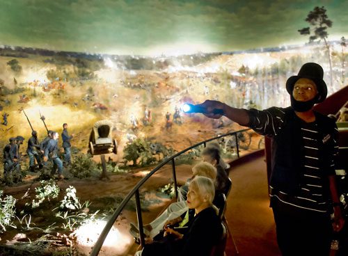 Derrick Williams (right) uses a flashlight to point out different features of the Cyclorama in the Grant Park neighborhood of Atlanta on Thursday, August 29, 2013.