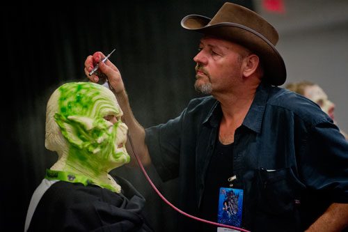Roy Wooley, one of the contestants on the SyFy Channel's FaceOff reality television show, airbrushes Jake Weissman's face during DragonCon in downtown Atlanta on Saturday, August 31, 2013.