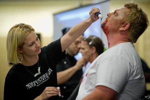 Laura Layne Taylor, one of the contestants on the SyFy Channel's FaceOff reality television show, applies some blood to Jason Pontius' face during DragonCon in downtown Atlanta on Saturday, August 31, 2013.