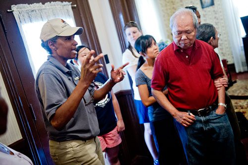 Elaine Edwards (left) talks about Martin Luther King Jr. as she gves Husen Wijaya (right) and others a tour of his birth home at the Martin Luther King Jr. National Historic Site in the Old Fourth Ward neighborhood of Atlanta on Wednesday, September 4, 2013. 