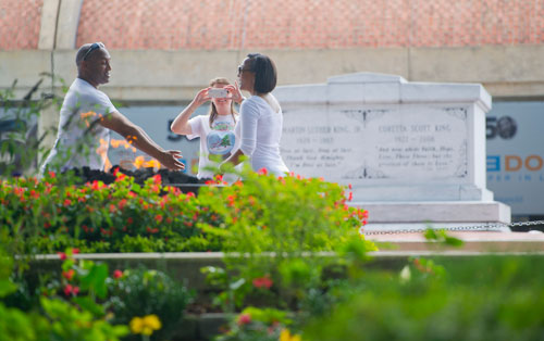 Mary Wagner (center) takes a photograph of Bruce Walton (left) and Sharon Strange Lewis in front of the eternal flame and Dr. and Mrs. Martin Luther King Jr.'s tombs at the Martin Luther King Jr. National Historic Site in the Old Fourth Ward neighborhood of Atlanta on Wednesday, September 4, 2013. 