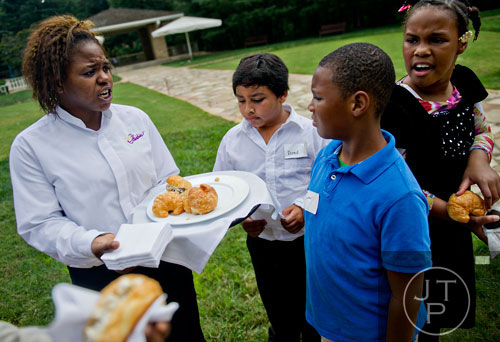 Shantell Fallen (left) serves chicken salad croissants to David Fili, Christopher Ellis and Ariell Taylor as they wait for the start of the first annual Fowler Family Celebration of Love at Villa Christina in Atlanta on Sunday, September 15, 2013. 