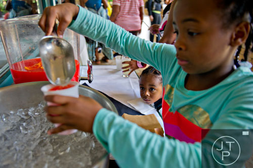 Bre-Lon Waters (center) watches as Mya McMann pours him a cup of punch as they wait for the start of the first annual Fowler Family Celebration of Love at Villa Christina in Atlanta on Sunday, September 15, 2013. 