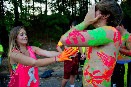 Lucy Mills (left) flings paint at J.T. Higginbottom as they prepare for before the Walton - Lassiter football game at Walton HIgh School in Marietta on Friday, October 4, 2013.  