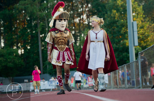 Lassiter mascots Allen Thomas (left) and Jordan Fast walk along the track before their game against Walton on Friday, October 4, 2013. 