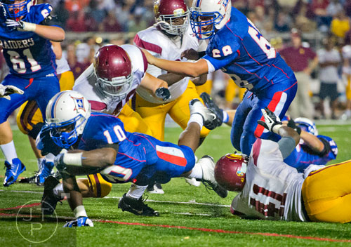 Walton's KK Brooks (10) dives for extra yards as Lassiter's Benedict Louis (41) tackles him on Friday, October 4, 2013. 