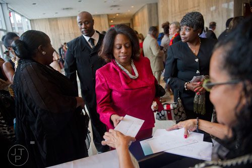 Brenda Davenport (center) picks up her ticket for I've Known Rivers: A Legendary Life, a tribute to Joseph E. Lowery's 92nd birthday celebration at Morehouse College in Atlanta on Sunday, October 6, 2013. 