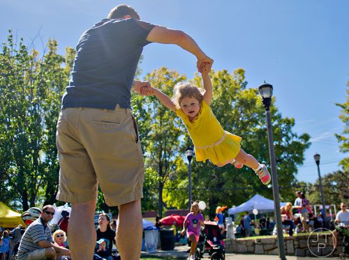 Maddie Murdocca (right) is spun in circles by her father Raffaele during the Oakhurst Arts & Music Festival at Harmony Park in Decatur on Saturday, October 12, 2013. 