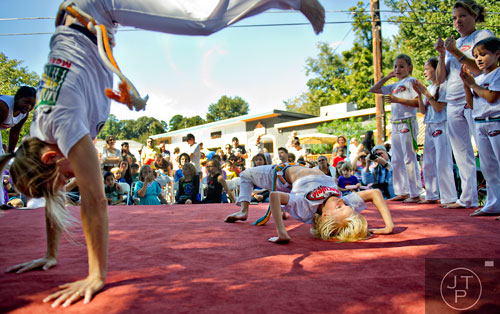 Julian Fortuna (right) and his mother Robin participate in a live capoeira demonstration during the Oakhurst Arts & Music Festival at Harmony Park in Decatur on Saturday, October 12, 2013.