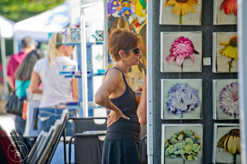 Ronni Rothman checks out the artist booths during the Oakhurst Arts & Music Festival at Harmony Park in Decatur on Saturday, October 12, 2013. 