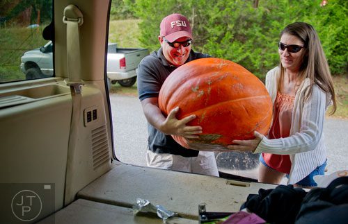 Scott Varn (left) and his wife Veronica lift thier pumpkin into the back of their SUV at Burt's Pumpkin Farm in Dawsonville on Sunday, October 13, 2013. 