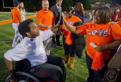 Former North Cobb and University of Georgia baseball player Johnathan Taylor (left) gives a high five to his mother Tandra after being inducted into the Class of 2013 North Cobb High School Athletic Hall of Fame  before the Warriors' game against McEachern on Friday, October 18, 2013.    