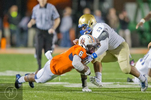 North Cobb's J'Vonte Herrod (6) is tackled by McEachern's Christian Wade (53) on Friday, October 18, 2013. 