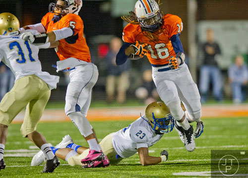 North Cobb's Devin Granville (16) breaks a tackle by McEachern's Tyler Woodley (23) as Torrance McGee (5) blocks Rahmoi Parsons (31) and Christian Ford (13) on Friday, October 18, 2013. 