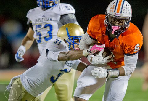 North Cobb's J'Vonte Herrod (6) is tackled by McEachern's Rahmoi Parsons (31) as he carries the ball up the field on Friday, October 18, 2013. 