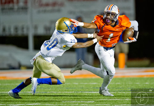 North Cobb's Latrell Gibbs (1) stiff arms McEachern's Jaylyn White (20) as he carries the ball up the field on Friday, October 18, 2013. 