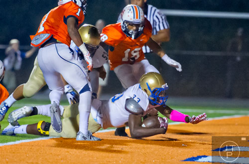 McEachern's Alizee Chubbs (33) dives into the endzone for a touchdown past North Cobb's Latrell Gibbs (1) on Friday, October 18, 2013. 