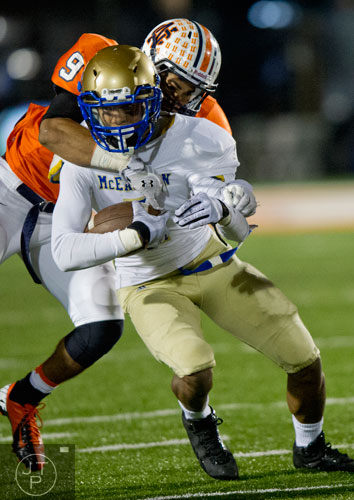 North Cobb's Myles Price (9) tries to stip the ball out of the hands of McEachern's Taj Griffin (front) as he carries the ball up the field on Friday, October 18, 2013.