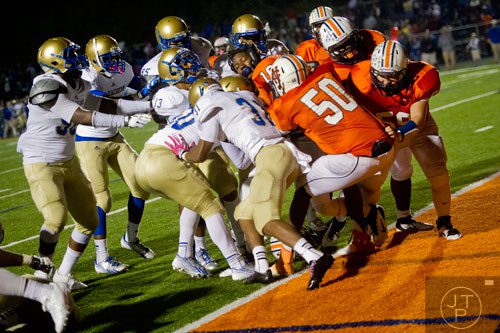 North Cobb's Devin Granville (center without helmet) is pulled into the endzone amongst a throng of players from both teams on Friday, October 18, 2013. 