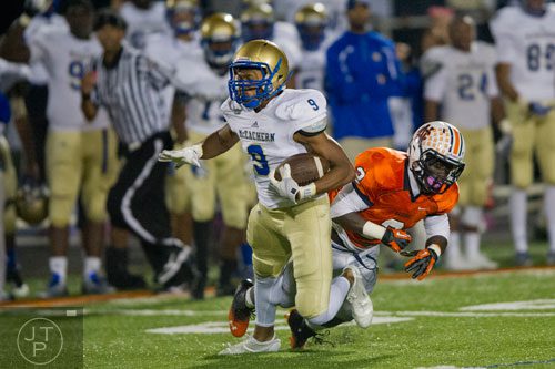 McEachern's Trey Scott (9) is tripped up by North Cobb's Jalil Kuku (2) on Friday, October 18, 2013. 