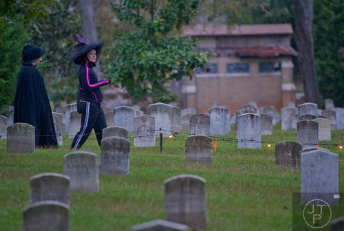 Karin Arranz (left) follows Jessica Harris through Oakland Cemetery in Atlanta as they head to the starting line for the 2013 Run Like Hell 5k on Saturday, October 19, 2013. 