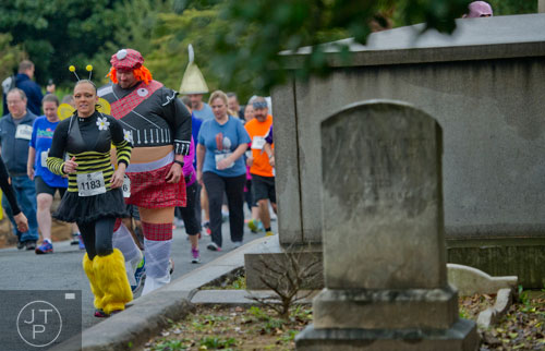 Aynne Owens (left) and Greg Pridgen run through Oakland Cemetery in Atlanta during the 2013 Run Like Hell 5k on Saturday, October 19, 2013. 