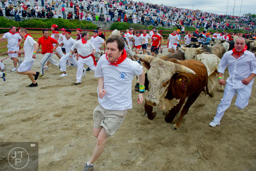 LEDE October 19, 2013 Conyers - An 1,800 pound bull chases after Bryant Knght during the Great Bull Run as he tries to run the quarter mile course at the Georgia International Horse Park in Conyers on Saturday, October 19, 2013. The first event of its kind in Atlanta, The Great Bull Run allowed participants to feel the same excitment as if they were running with the bulls in Pamplona, Spain.   JONATHAN PHILLIPS / SPECIAL