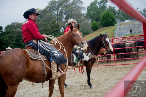 Preston Fowlkes (left) and Clint Madison sit atop their horses as they wait to drive 18, 1,800 pound bulls around a quarter mile course as participants run during the Great Bull Run at the Georgia International Horse Park in Conyers on Saturday, October 19, 2013. 