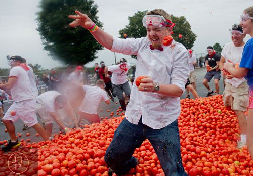 Brandon Roth gets hit in the face with a tomato as thousands of people hurl the red vegetables at each other during the Tomato Royale portion of the Great Bull Run at the Georgia International Horse Park in Conyers on Saturday, October 19, 2013.