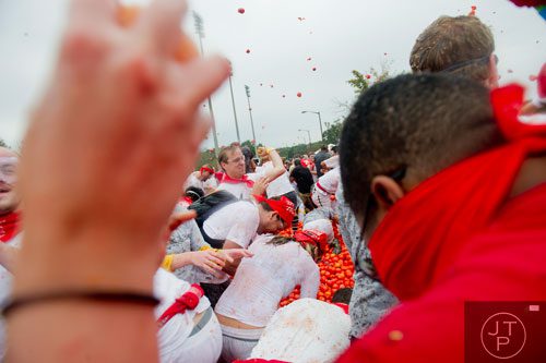 Thousands of people hurl tomatoes at each other during the Tomato Royale portion of the Great Bull Run at the Georgia International Horse Park in Conyers on Saturday, October 19, 2013.