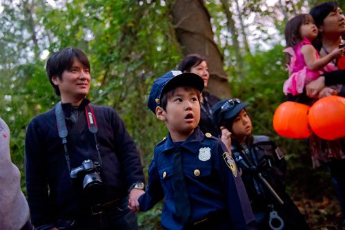 Toji Okada (center) holds his father Nobuhiro's hand as they walk the trails at the Chatthoochee Nature Center in Roswell during a Halloween Hike on Saturday, October 19, 2013.