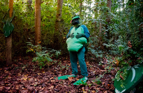 Dressed as a bullfrog, Melodie Mason entertains a group of hikers as they walk the trails at the Chatthoochee Nature Center in Roswell during a Halloween Hike on Saturday, October 19, 2013.