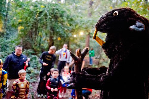 Dressed as a beaver, David Weiss (right) entertains a group of hikers as they walk the trails at the Chatthoochee Nature Center in Roswell during a Halloween Hike on Saturday, October 19, 2013. 