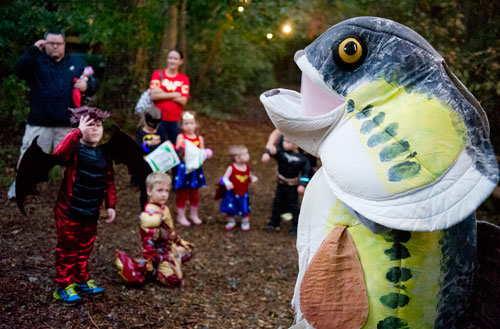 Dressed as a large mouthed bass, Nikki Murphy (right) entertains a group of hikers as they walk the trails at the Chatthoochee Nature Center in Roswell during a Halloween Hike on Saturday, October 19, 2013.