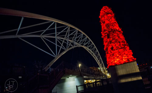A piece of artwork glows in the dark as a pedestrian bridge spans over the highway in downtown Denver, Colorado on Friday, October 25, 2013.