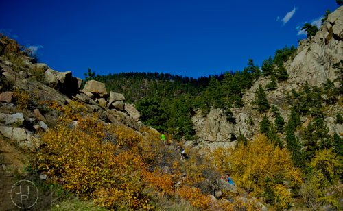 A family rock climbs up the side of a cliff next to Boulder Creek outside of Boulder, Colorado on Sunday, October 27, 2013.