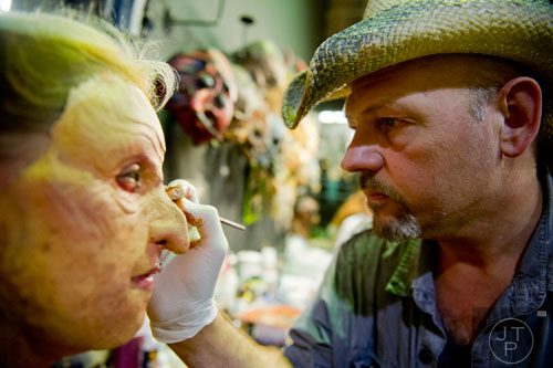 Roy Wooley (right) applies makeup to Jacqueline Trade's face as she prepares to scare people at Netherworld Haunted House in Norcross on Monday, October 7, 2013.