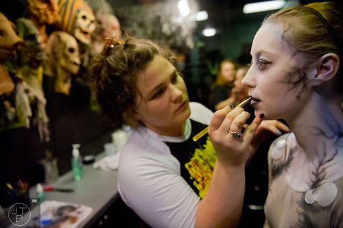 Hayley Platt (right) has makeup applied by Hope Ferguson as she gets ready to scare visitors to Netherworld Haunted House in Norcross on Monday, October 7, 2013.
