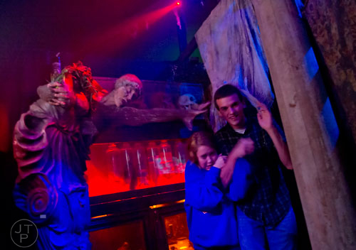 Chris Taylor (left) reaches out for Alyssa Goble and Robert Bedsole as they make their way through "The Dead Ones", this year's theme at Netherworld Haunted House in Norcross, on Monday, October 7, 2013.