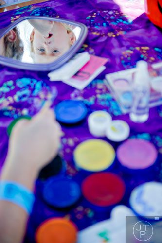 Mims Pettit (top) watches as Leanne Aspinall paints her sister's face during Parktoberfest at Whittier Mill Park in Atlanta on Saturday, October 12, 2013. 