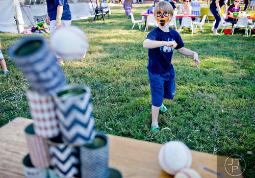 Isaac Zderski tries to knock over a stack of cans during Parktoberfest at Whittier Mill Park in Atlanta on Saturday, October 12, 2013.