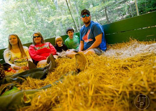 Rodney McClure (right), his children Tyler and Miley, Danielle Smith and her daughterLindsay take a hayride around Burt's Pumpkin Farm in Dawsonville on Sunday, October 13, 2013.