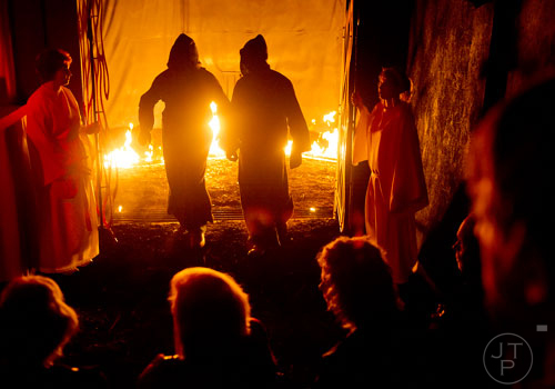 Carolyn Burruss (left) and Dawn Baus (right) open up the gates to the Lake of Fire as Roger Jameson (center left) and Chris Dearwent enter a scene of Hell's Gates to claim a soul at Lighthouse Baptist Church in Dawsonville on Thursday, October 17, 2013. 