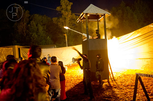 Pyrotechnics go off as Levi Kennedy mans a 50 caliber machine gun in a tower during Hell's Gates at Lighthouse Baptist Church in Dawsonville on Thursday, October 17, 2013.