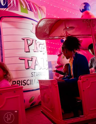 Elle Reeder (left) and her mother Nina ride the Macy's Pink Pig at Lenox Square Mall in Buckhead on Saturday, November 2, 2013. 