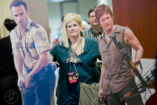 K.K. McKay (center) walks with life size standups of Andrew Lincoln and Norman Reedus  during Walker Stalker Con at the Atlanta Convention Center at AmericasMart on Saturday, November 2, 2013. 